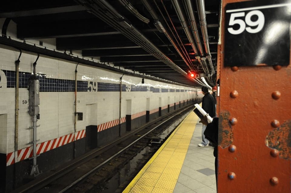 A person standing on the platform of a train station.