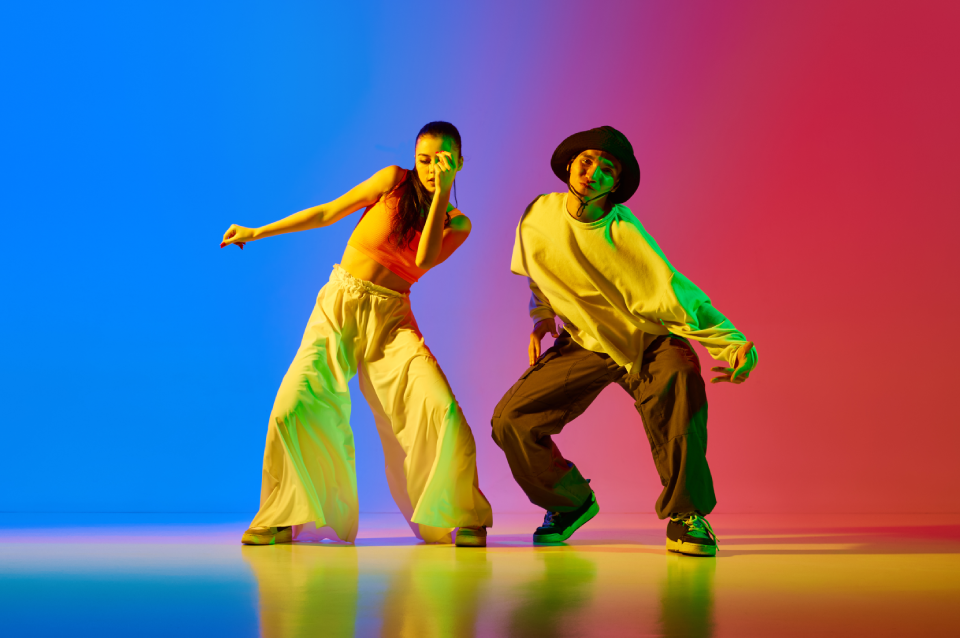 Two dancers in colorful studio lighting