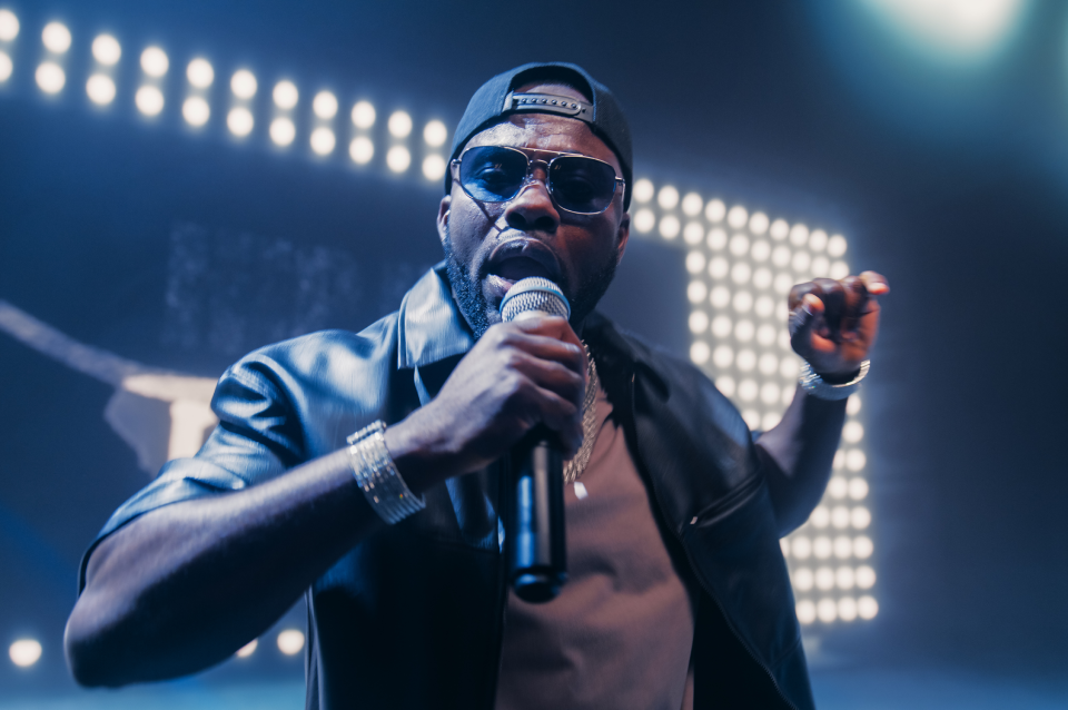 Rapper on stage with microphone and lights